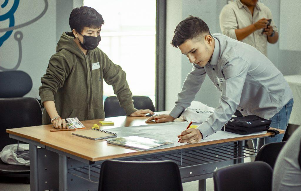 Pessoas sentadas ao redor de uma mesa de escritório

Descrição gerada automaticamente